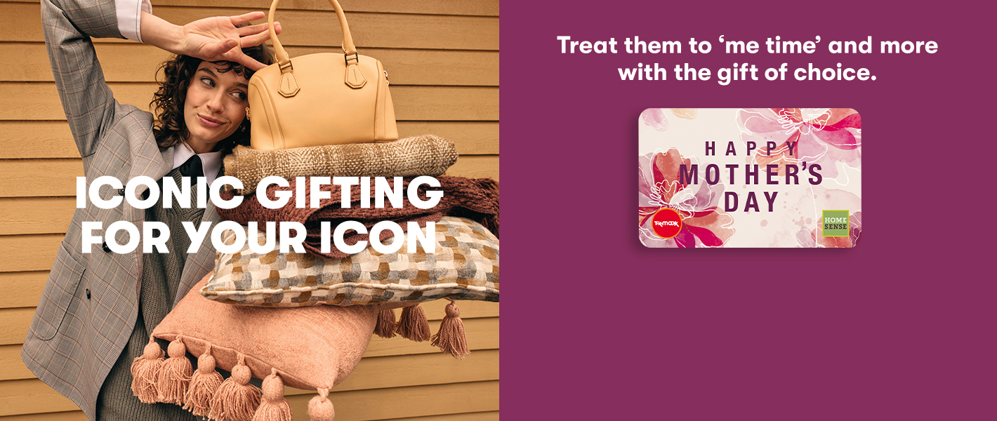 Smiling woman balancing a handbag on top of blankets and cushions. With ‘Iconic gifting for your icon’ headline and ‘Shop gift cards’ CTA.